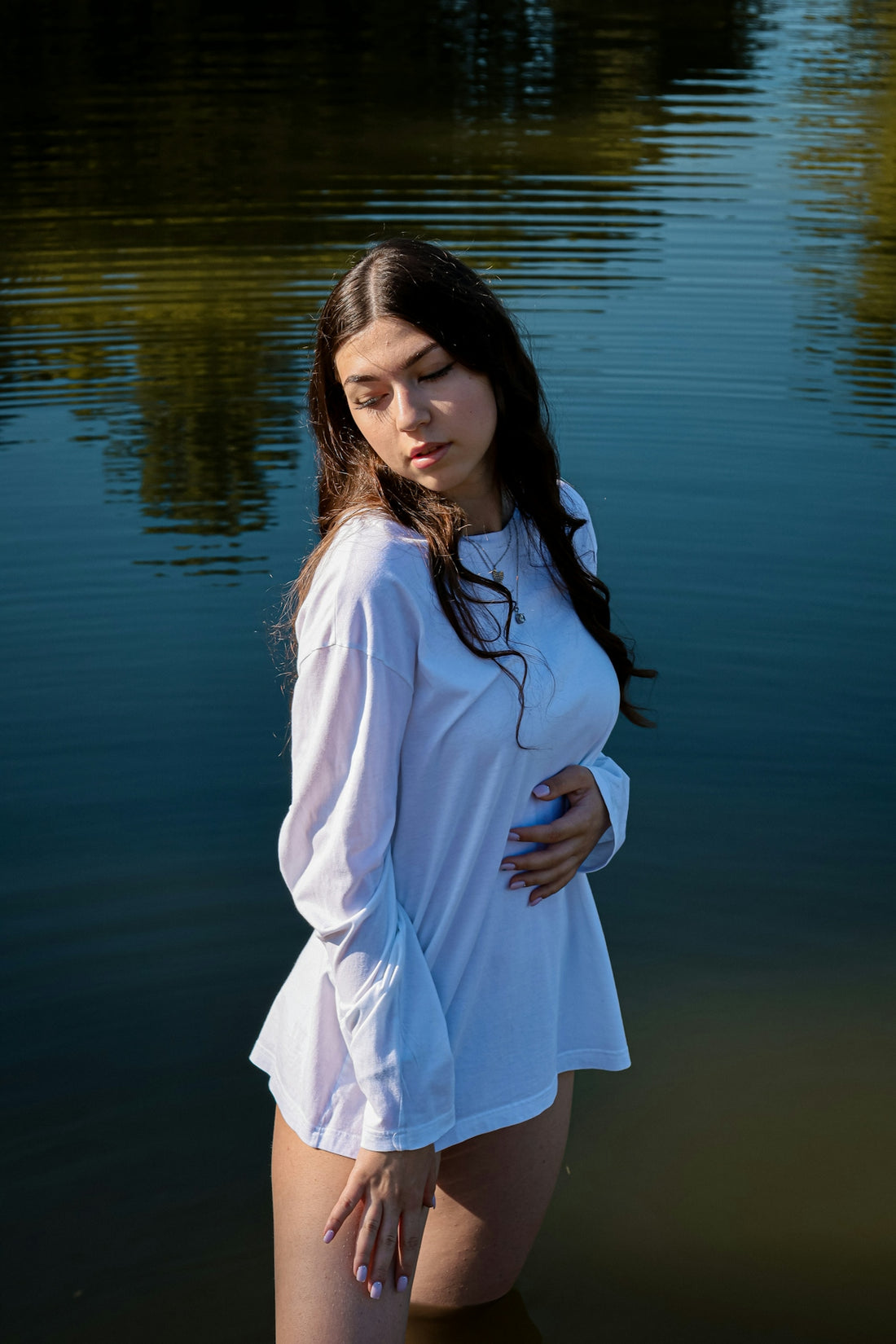 woman in white long sleeve dress standing near body of water during daytime
