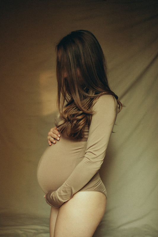 A pregnant woman is posing for a picture