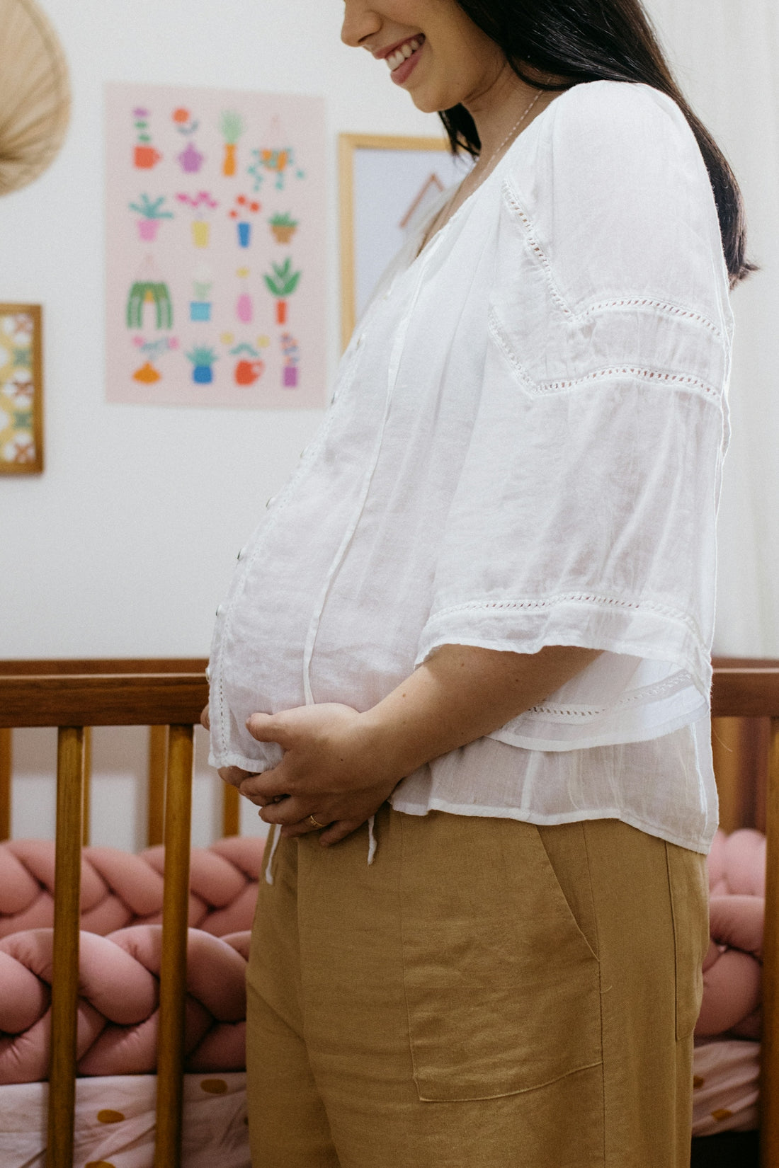 A pregnant woman standing in her crib