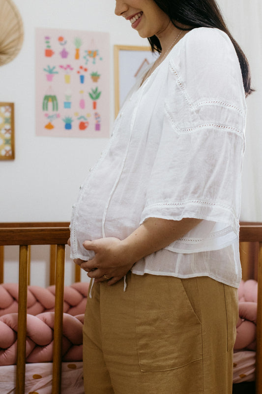 A pregnant woman standing in her crib