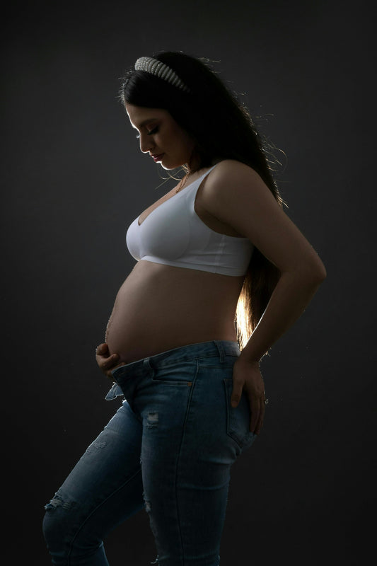 A pregnant woman poses in silhouette.